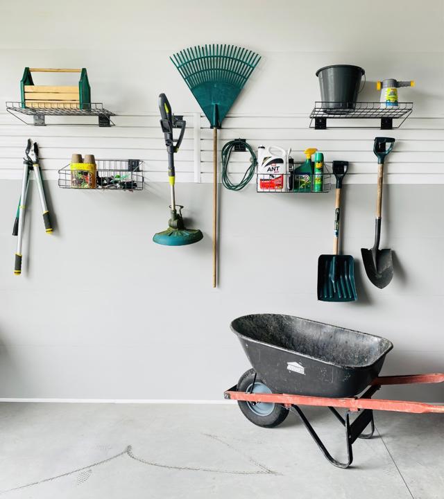 Panneaux de revêtement à rainures SlatWall blanc dans un garage avec des outils accrochés.