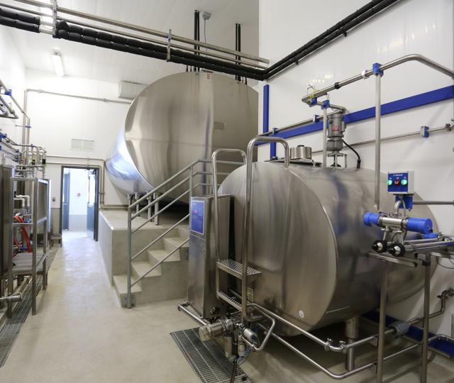 Trusscore wall panels in a dairy processing room with tanks.