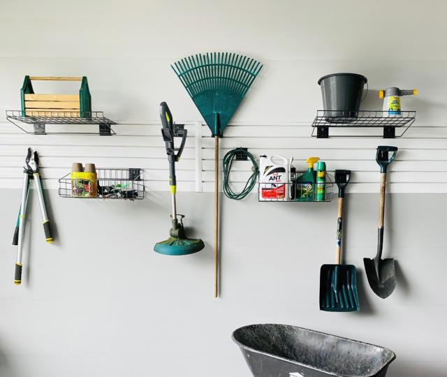 Panneaux de revêtement à rainures SlatWall blanc dans un garage avec des outils accrochés.