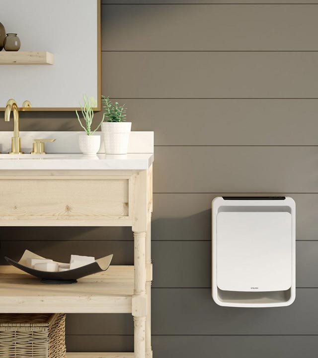 Fan heater mounted on a bathroom wall, next to a wooden sink.