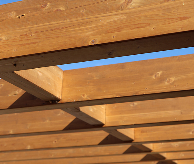 Solives en bois de pergola formant une structure extérieure décorative pour terrasse ou espace de détente.