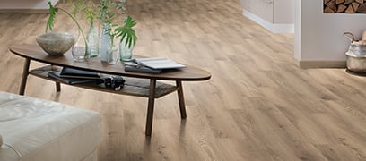 Beau plancher stratifié de couleur brun dans un salon avec table basse et divan blanc en cuir
