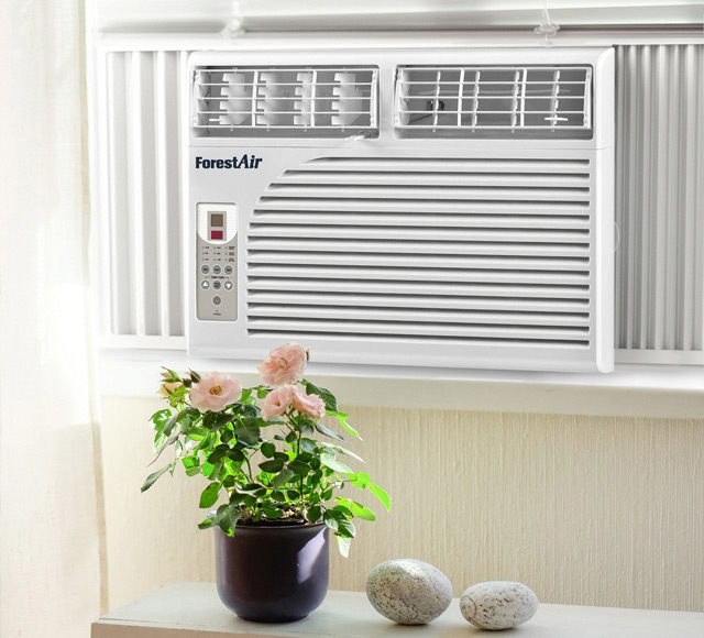 Climatiseur de fen&ecirc;tre blanc install&eacute; dans une pi&egrave;ce lumineuse, avec panneau de commande lat&eacute;ral et plante d&eacute;corative au premier plan.