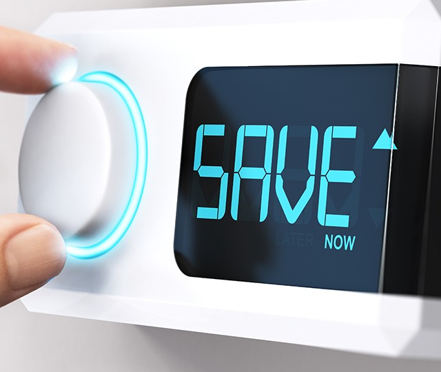 Thermostat intelligent mural avec &eacute;cran num&eacute;rique affichant &ldquo;SAVE&rdquo;, ajust&eacute; &agrave; l&rsquo;aide d&rsquo;un bouton rotatif lumineux.