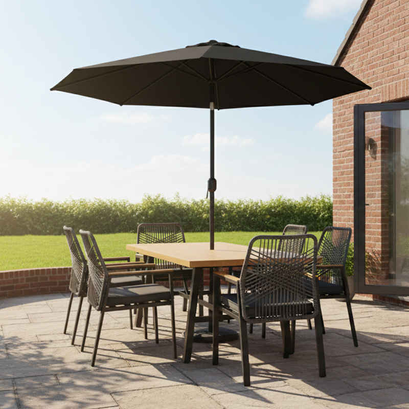 Patio furniture set featuring an outdoor dining table, six chairs, and an umbrella, arranged on a paved terrace in front of a brick house.