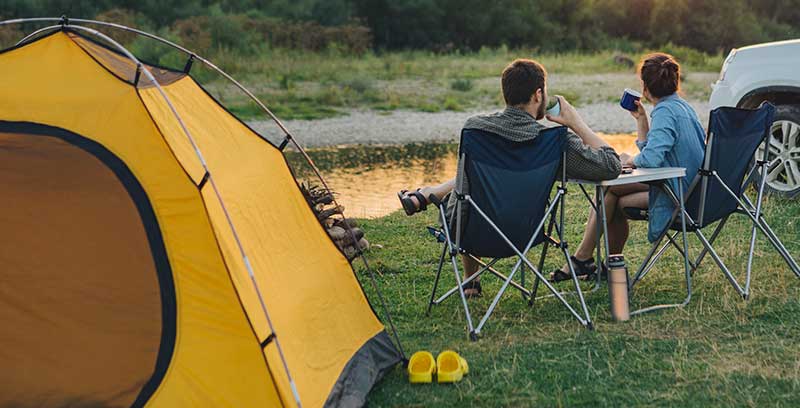 Yellow camping tent near a lake
