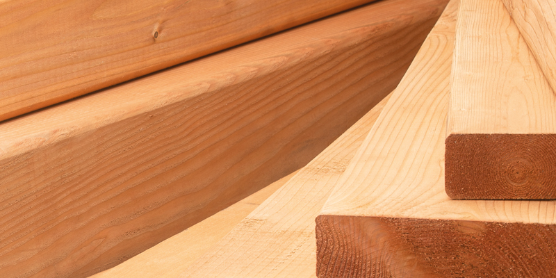 Planches de bois trait&eacute; empil&eacute;es, utilis&eacute;es pour la construction ext&eacute;rieure et les projets d&rsquo;am&eacute;nagement.