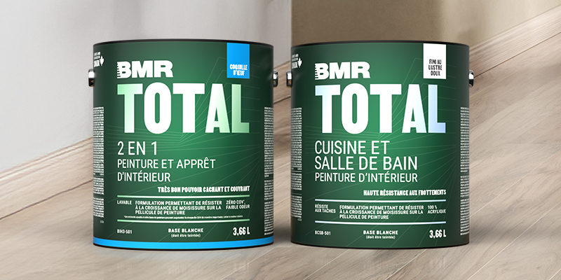 Deux pots de peinture int&eacute;rieure BMR Total 2 en 1 et Cuisine et salle de bain, format 3,66 L, pos&eacute;s sur un plancher de bois.