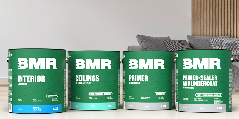 Four gallons of BMR interior paint—including interior latex paint, ceiling paint, primer, and primer-sealer—displayed in a modern living room.