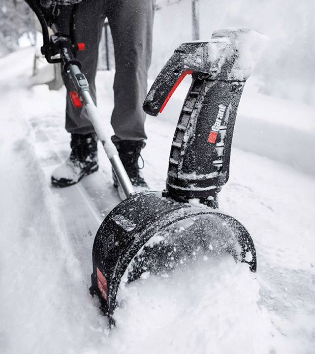 Garant electric snow blower being used to clear a snowy walkway.