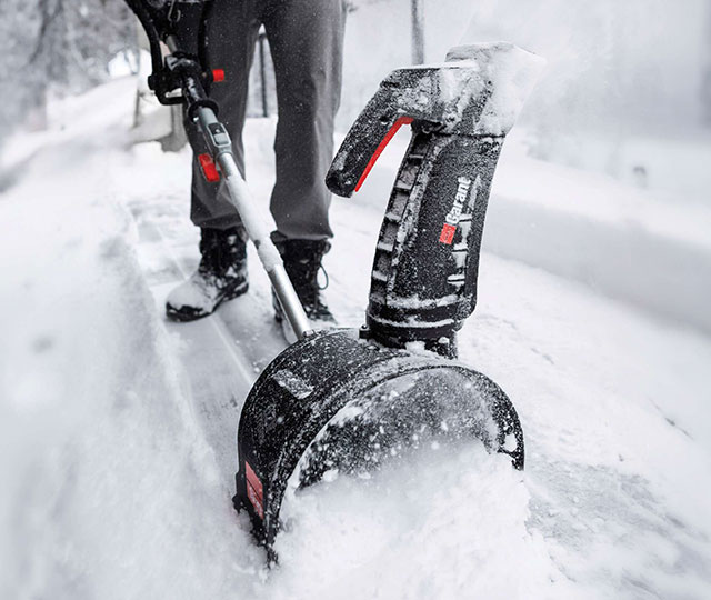 Garant electric snow blower being used to clear a snowy walkway.