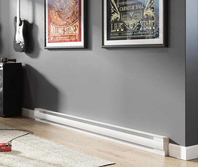 Electric baseboard heater installed at the foot of a dark gray wall, beneath two frames next to an electric guitar and a speaker.