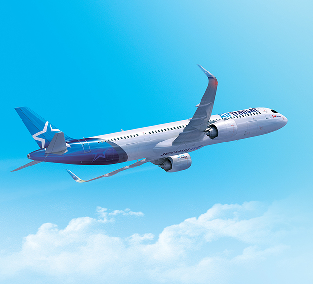 Air Transat passenger airplane flying in a blue sky above the clouds.