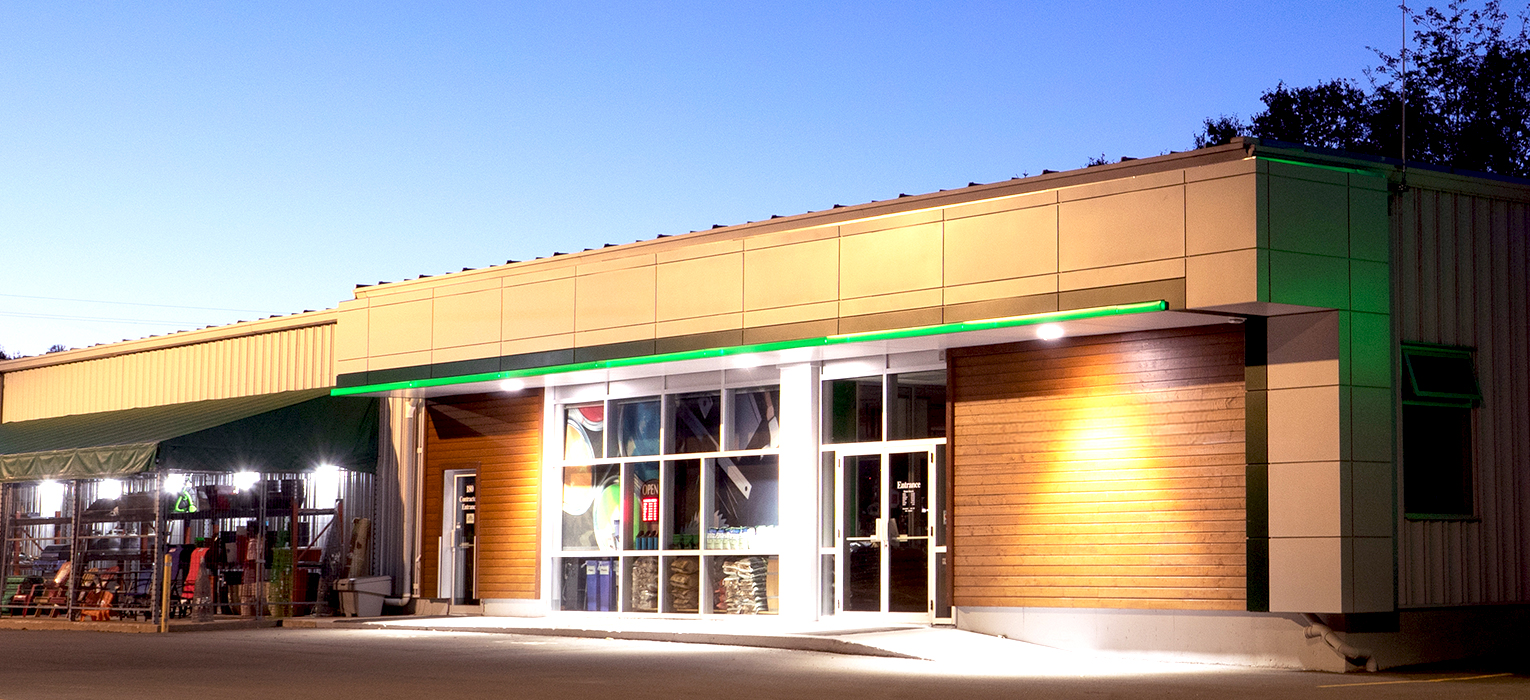 Front entrance of a BMR Express store at dusk, featuring the illuminated storefront and main entrance.