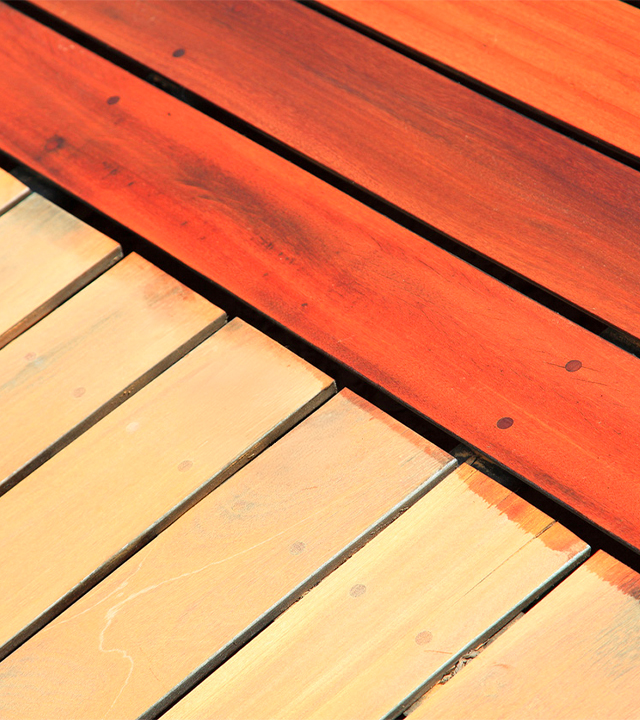 Application uniforme de teinture sur planches de terrasse en bois à l’aide d’un pinceau et d’un bac de produit